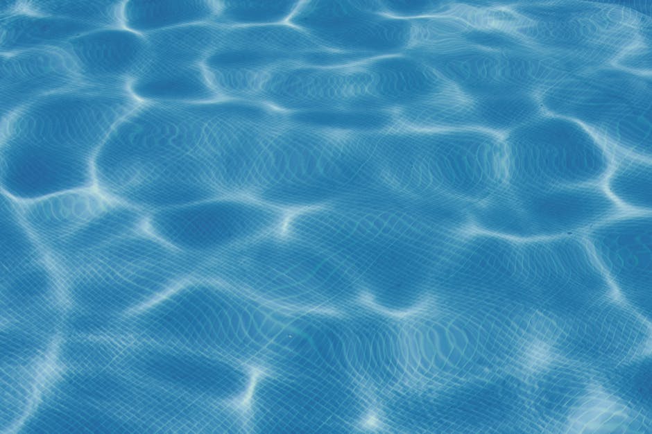 Clear blue water surface reflecting sunlight, perfect for summer themes.
